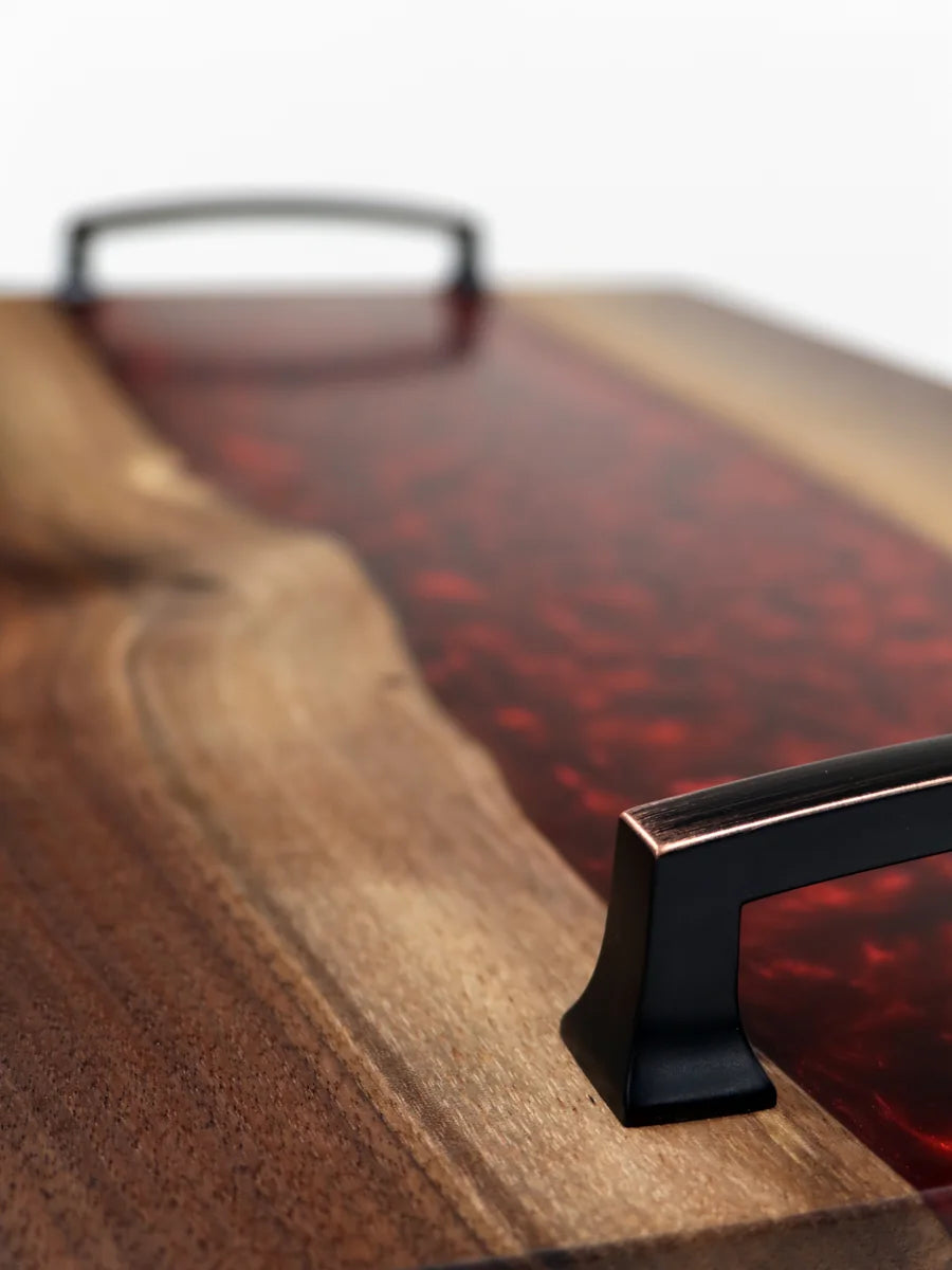 A walnut charcuterie board with a river of aqua resin through it.