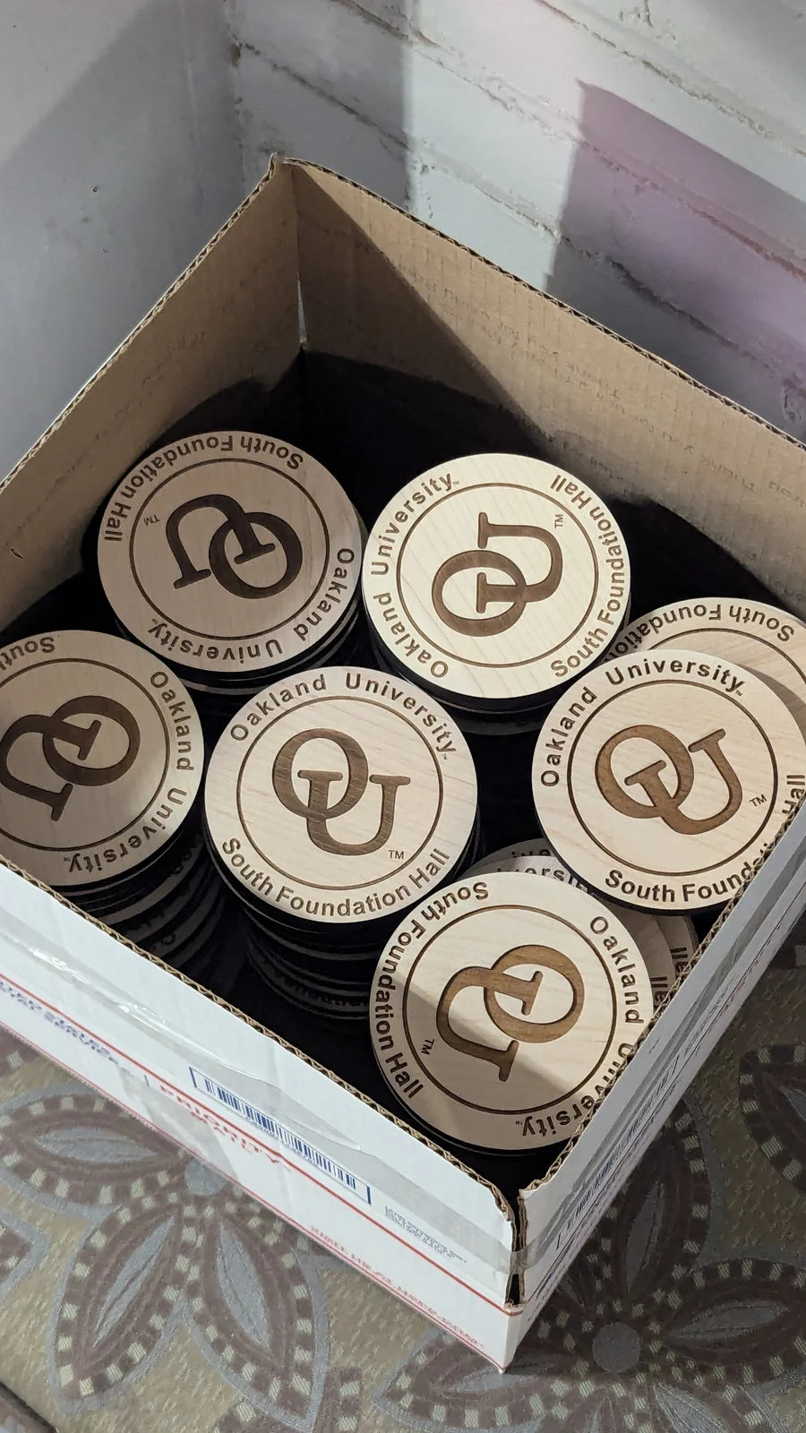 Finished Oakland University coasters packed into a box.