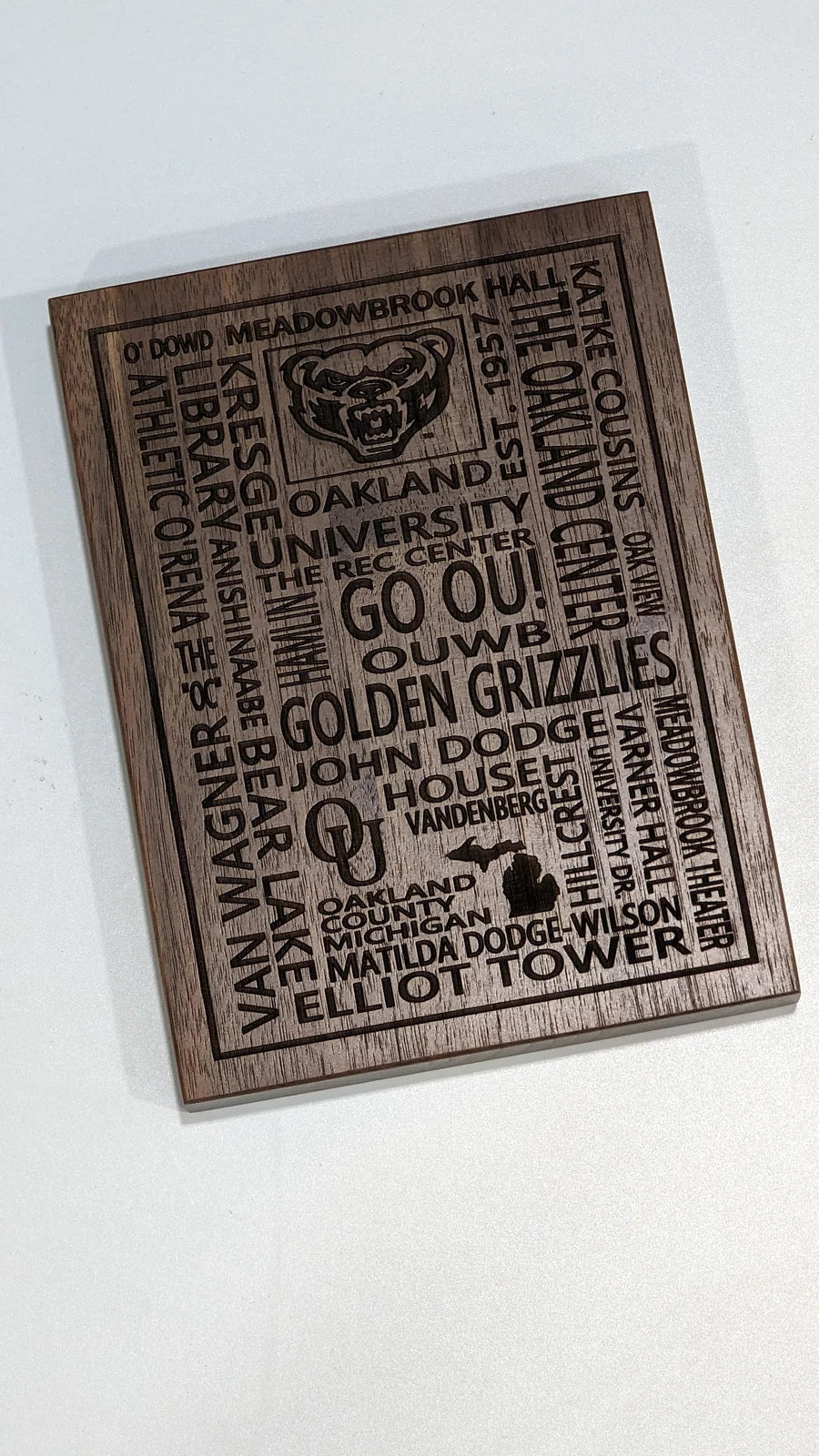 The same Oakland University word plaque cut in walnut.