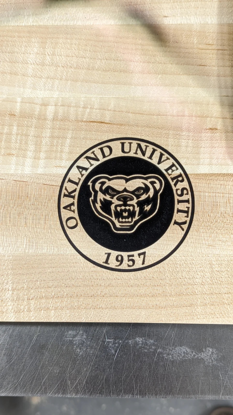 Close detail of the Oakland University seal engraved into figured maple.