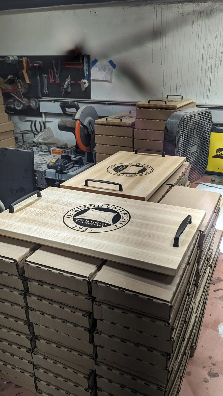 Stacks of cut tray blanks with a finished engraved tray resting on top.