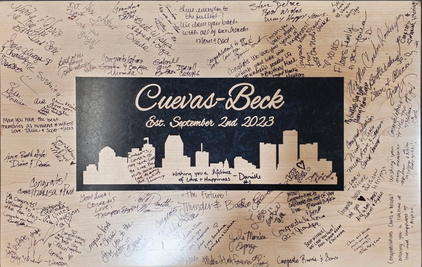 A custom engraved wooden wedding piece signed by the guests.